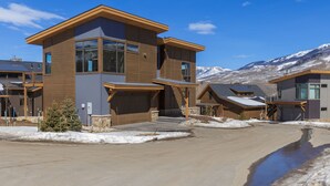 A modern multi-story residential building with a prominent garage and large windows. - Spacious Mountain Home, Panoramic View from Private Balcony, Central Location (Silverthorne)