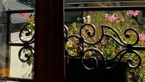 A view from a window with a metal balcony railing, a mountain landscape with snow-capped peaks, and a clear blue sky. - Hôtel du Clocher (Chamonix-Mont-Blanc)