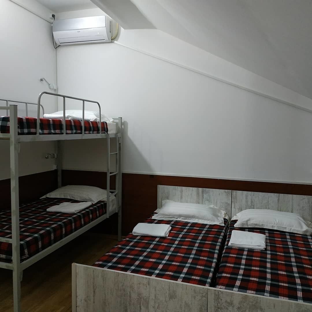 Un dormitorio con literas, un cabecero de madera y un equipo de aire acondicionado en la pared.