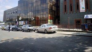Un edificio moderno con amplios ventanales y un anuncio de un gimnasio.