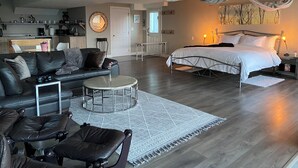 A modern living room with a sofa, coffee table, and a bed with a canopy.
