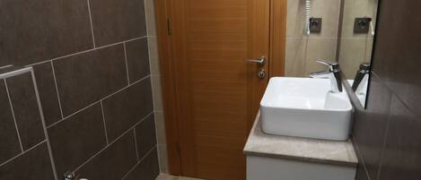 A bathroom with a toilet, sink, and wooden door.