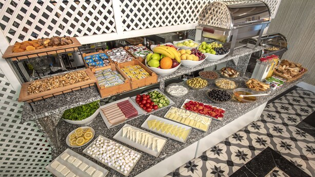 A buffet with various food items including fruits, vegetables, cheeses, and bread. - Mezzo Hotel (Istanbul)