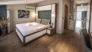 A modern hotel room with a large bed, bedside tables, a wall-mounted air conditioner, and a painting. - Mezzo Hotel (Istanbul)