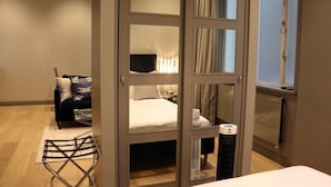 A hotel room with a bed, a chair, a radiator, and a window. - No.8 Waterloo Apartments (Birmingham)