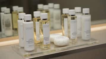A display of various toiletries including bottles of lotion and soap on a glass shelf.