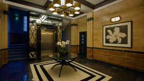 A lobby with a glass table, a potted plant, a framed artwork, and a staircase. - No.8 Waterloo Apartments (Birmingham)