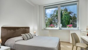 A bedroom with a bed, a desk, and a chair.