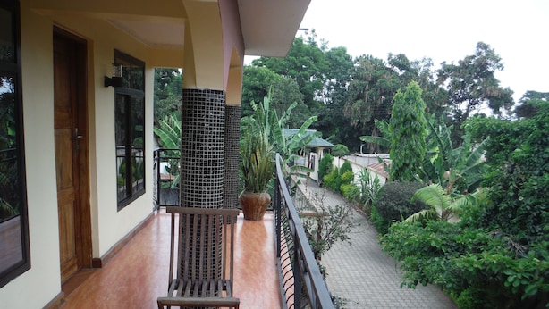 A balcony with a wooden bench and a potted plant. - Bright Star Hotel (Arusha)
