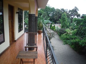 A balcony with a wooden bench and a potted plant. - Bright Star Hotel (Arusha)
