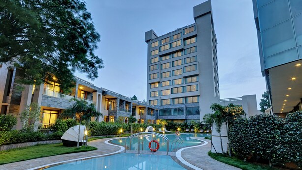 A modern hotel with a swimming pool, multiple floors, and well-lit outdoor areas. - Boulevard9, Nadiad – IHCL SeleQtions (Nadiad)