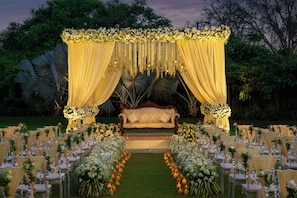 Montaje para una boda al aire libre con una carpa, arreglos florales y un sofá.