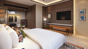 A modern hotel room with a large bed, a desk with a computer, a TV, and a ceiling fan. - Boulevard9, Nadiad – IHCL SeleQtions (Nadiad)