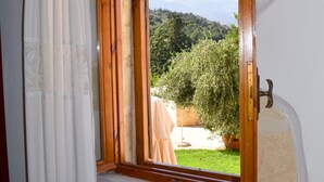 Une pièce avec une fenêtre à cadre en bois, des murs blancs et une vue sur la verdure.