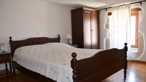 Une chambre à coucher avec un lit en bois, une armoire et une table de chevet avec une lampe.