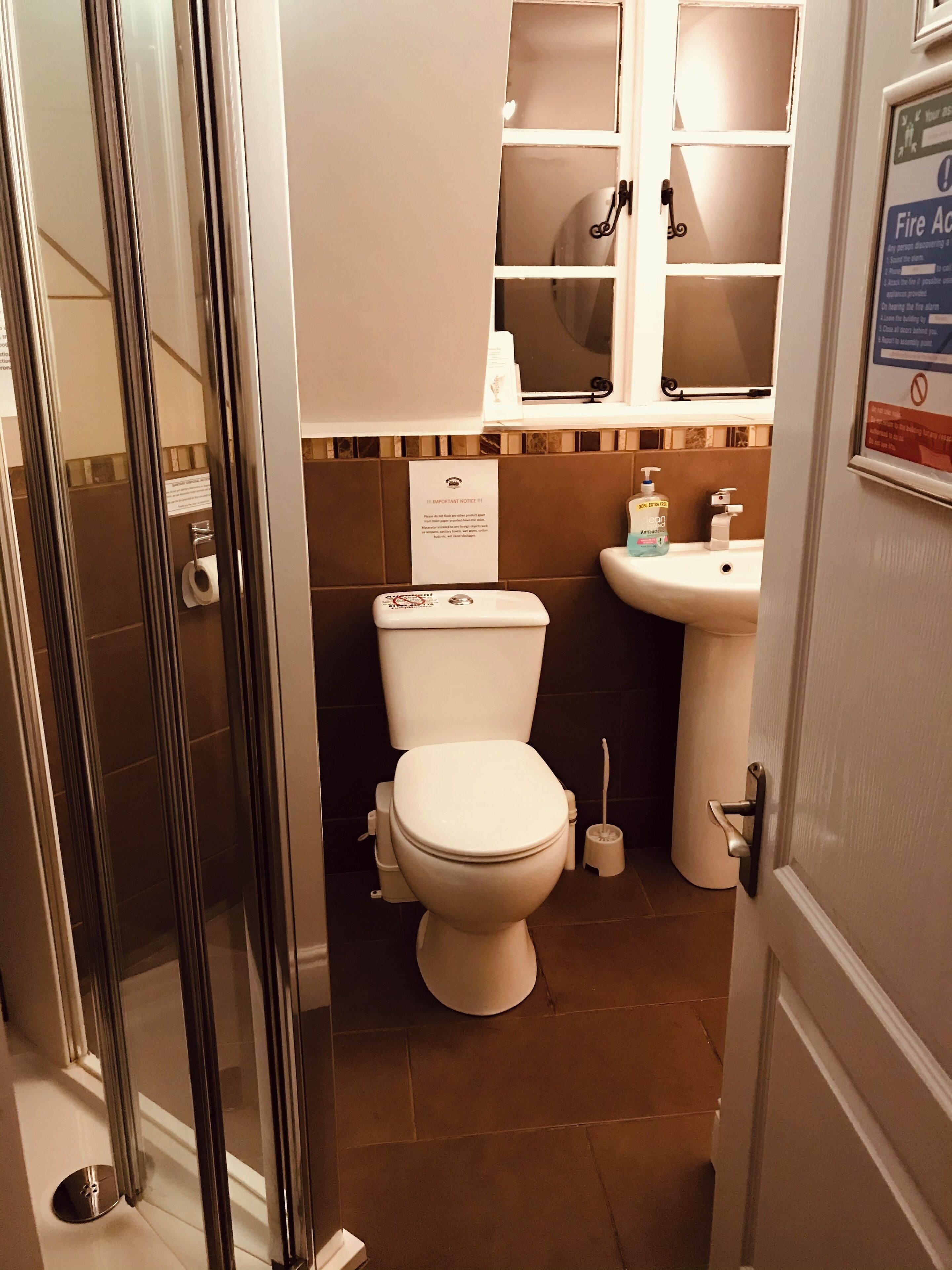 A bathroom with a toilet, sink, and a shower area.