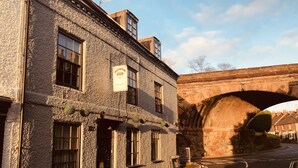 A stone building with multiple windows and a sign above the entrance. - Severn Valley Guest House (Bewdley)