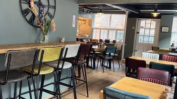 Een restaurantinterieur met een klok, een menubord en een bordje met de tekst 'SEVERN VALLEY'.