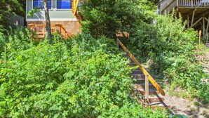 Eine Hütte mit einer Holzdiele und einer Treppe, die zu einem Balkon im zweiten Stock führt.