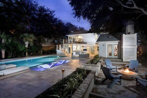 A modern house with a pool, outdoor seating, and a fire pit. - 3405 Cameron by AvantStay | Pool, Outdoor Kitchen (Isle of Palms)