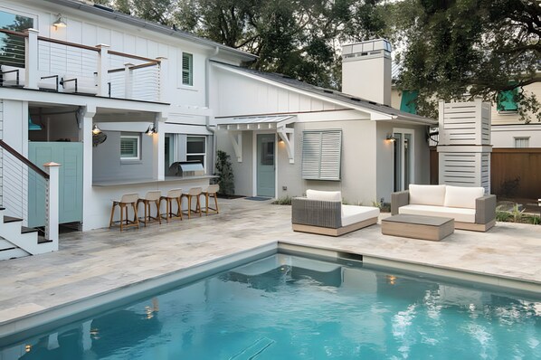 A modern house with a swimming pool, outdoor seating, and a covered patio. - 3405 Cameron by AvantStay | Pool, Outdoor Kitchen (Isle of Palms)