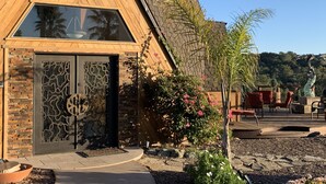 A modern building with a large glass window, a stone facade, and a wooden entrance. - California Dreamin' Upscale Architectural marvel / Horizon ocean view on 3 acres (Arroyo Grande)