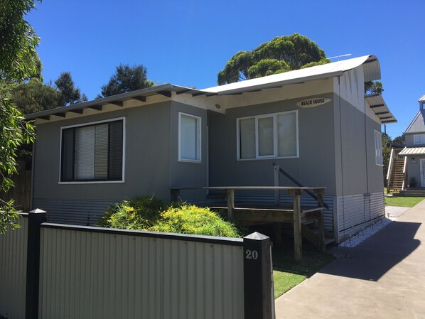 A two-story mobile home with a balcony, a small porch, and a staircase leading to the upper level.