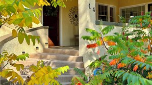 Una casa con el número 14 en la pared, una puerta principal y una escalera que lleva a la entrada.