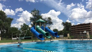 Una piscina con tobogán y torre de salvavidas.