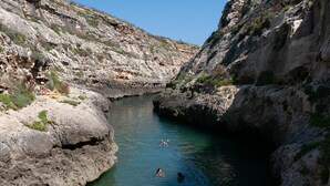 A rocky canyon with a narrow water channel. - Cosy Air-conditioned Studio Marsalforn Beach (Marsalforn, Żebbuġ Gozo)