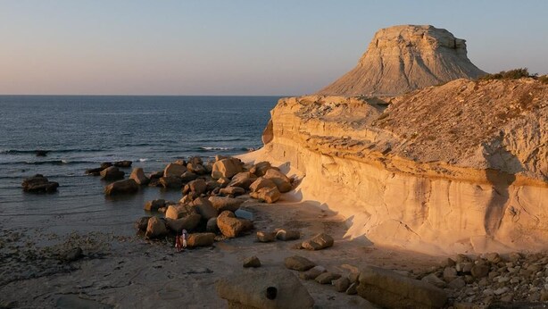 A coastal landscape with a prominent rock formation and a clear sky. - Cosy Air-conditioned Studio Marsalforn Beach (Marsalforn, Żebbuġ Gozo)