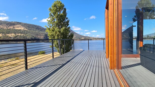 Eine Holzterrasse mit Blick auf einen See und Berge.