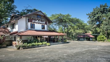 A two-story building with a red-tiled roof and a sign in a foreign language.