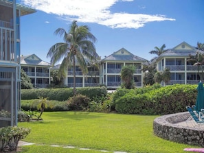 A resort with multiple buildings, a well-maintained lawn, and palm trees. - Plantation Village #20 | 3BR Ocean View Condo on Seven Mile Beach (George Town)