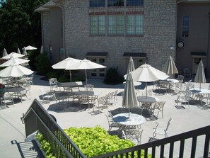 Enjoy communal dining and socializing in this outdoor space with comfortable seating and umbrellas.