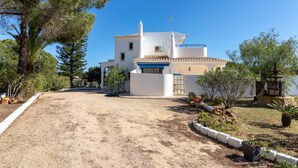 A white building with a blue door and a small garden area with plants and a fountain. - Casa Prensa - Private pool, 5 minute drive to Carvoeiro & beach (Lagoa)