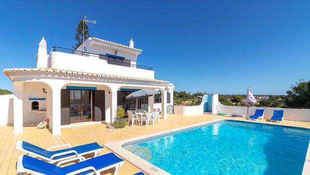 A pool area with lounge chairs and a building with a terrace. - Casa Prensa - Private pool, 5 minute drive to Carvoeiro & beach (Lagoa)