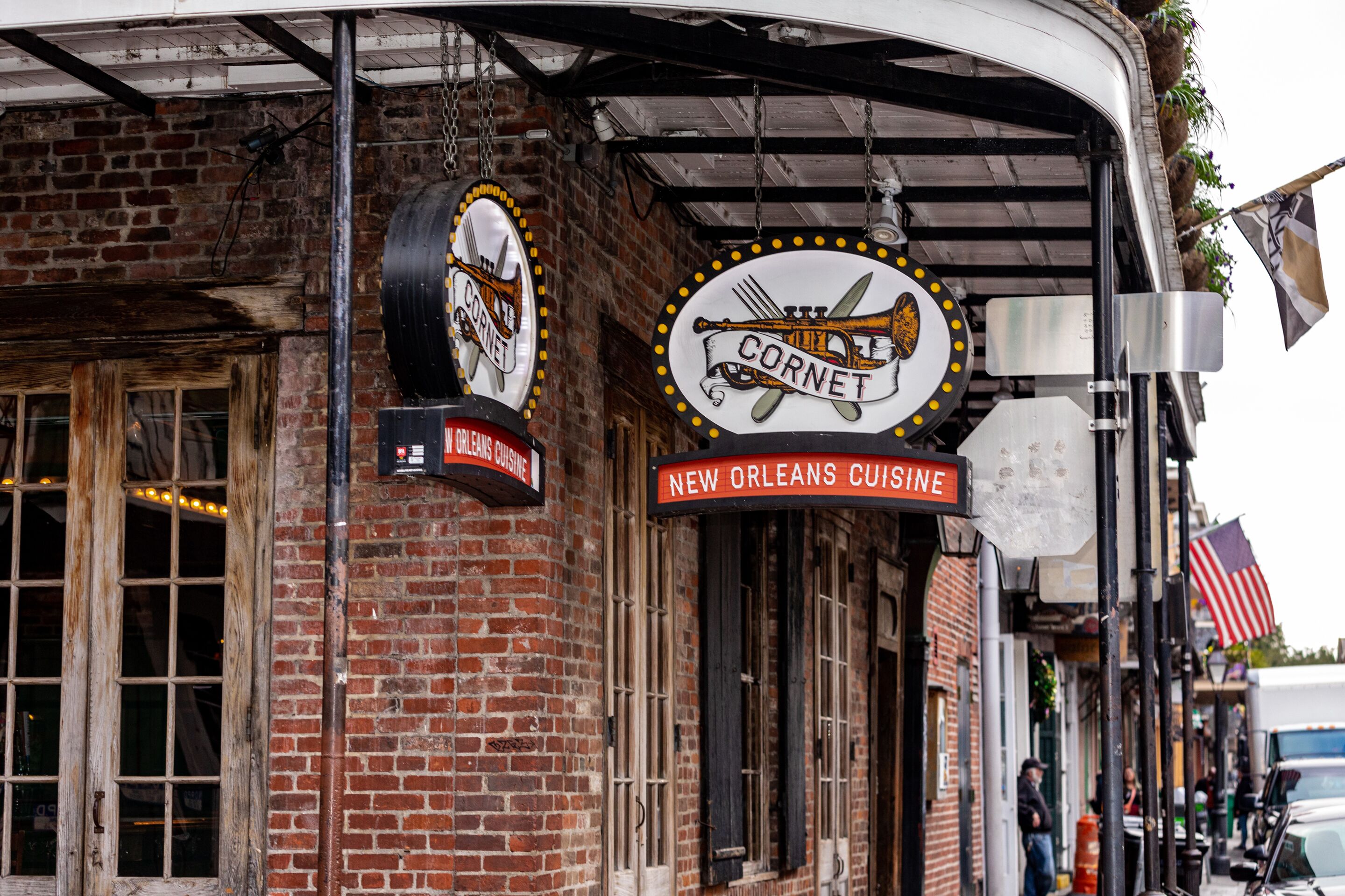 Een bakstenen gebouw met borden waarop 'CORNET' en 'NIEUW-ORLEANS KEUKEN' staan.