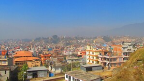 A densely packed urban area with a variety of building styles and colors, including red, orange, and yellow. - Sunrise Homestay Nepal (Tohka)