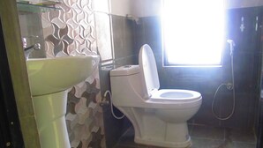A bathroom with a toilet, sink, and shower. - Sunrise Homestay Nepal (Tohka)