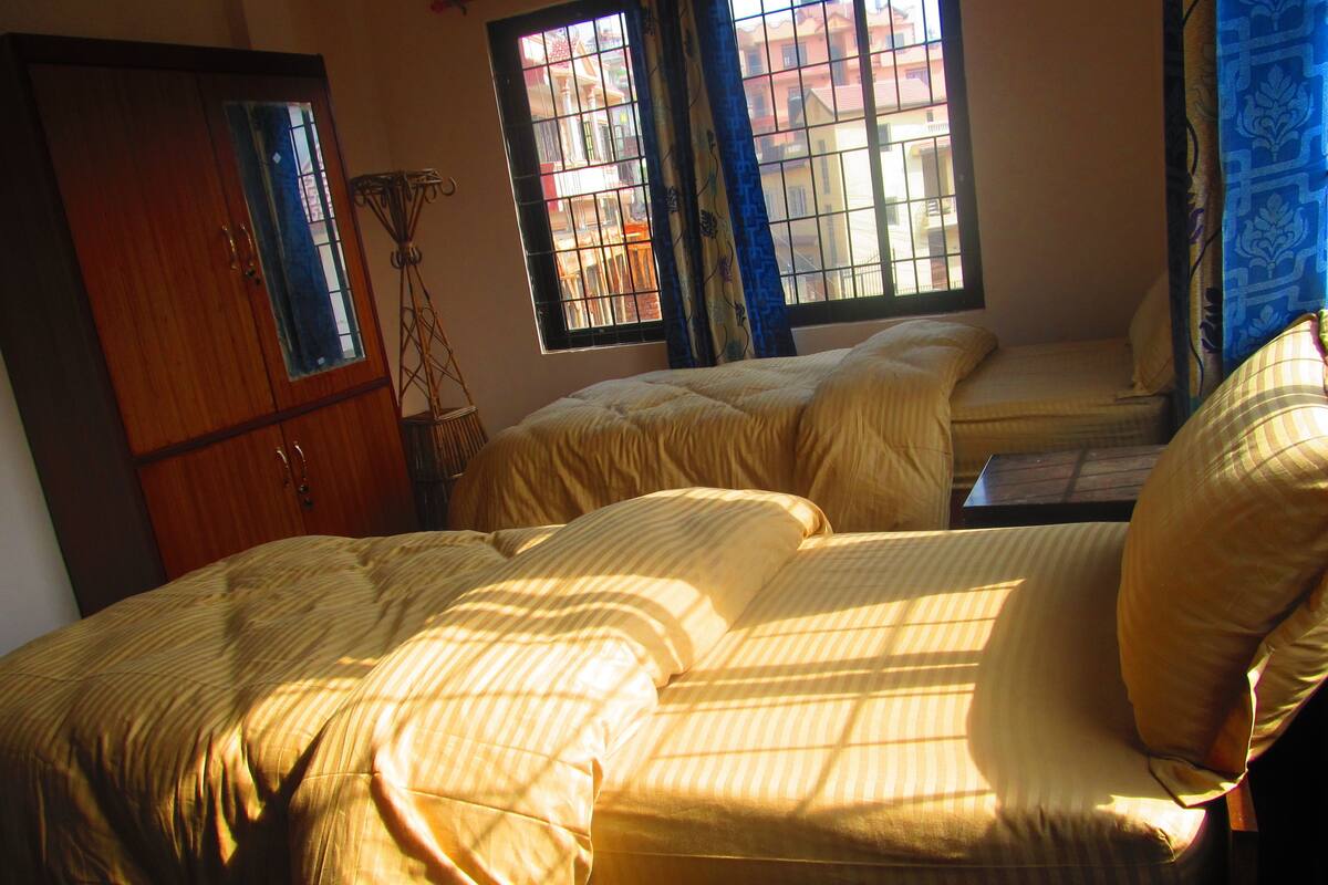 A room with a bed, a small table, and a window with bars.