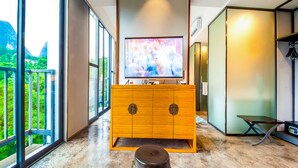 A modern bathroom with a wooden vanity, a large mirror, and a television. - Courtyard Hotel – Li River Branch (Guilin)