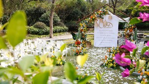A wedding ceremony setup with white chairs and floral decorations. - Courtyard Hotel – Li River Branch (Guilin)