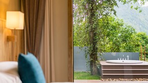 A bedroom with a view of a garden and a bathroom with a bathtub. - Moon Villa Resort (Guilin)