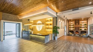 A reception area with a wooden reception desk, a brick wall, and a fireplace. - Moon Villa Resort (Guilin)