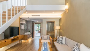 A modern living room with a wooden staircase, a sofa set, a coffee table, and a television. - Moon Villa Resort (Guilin)