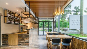 A modern restaurant with a wooden floor, a bar area with wine bottles, and a view of the outdoors. - Moon Villa Resort (Guilin)