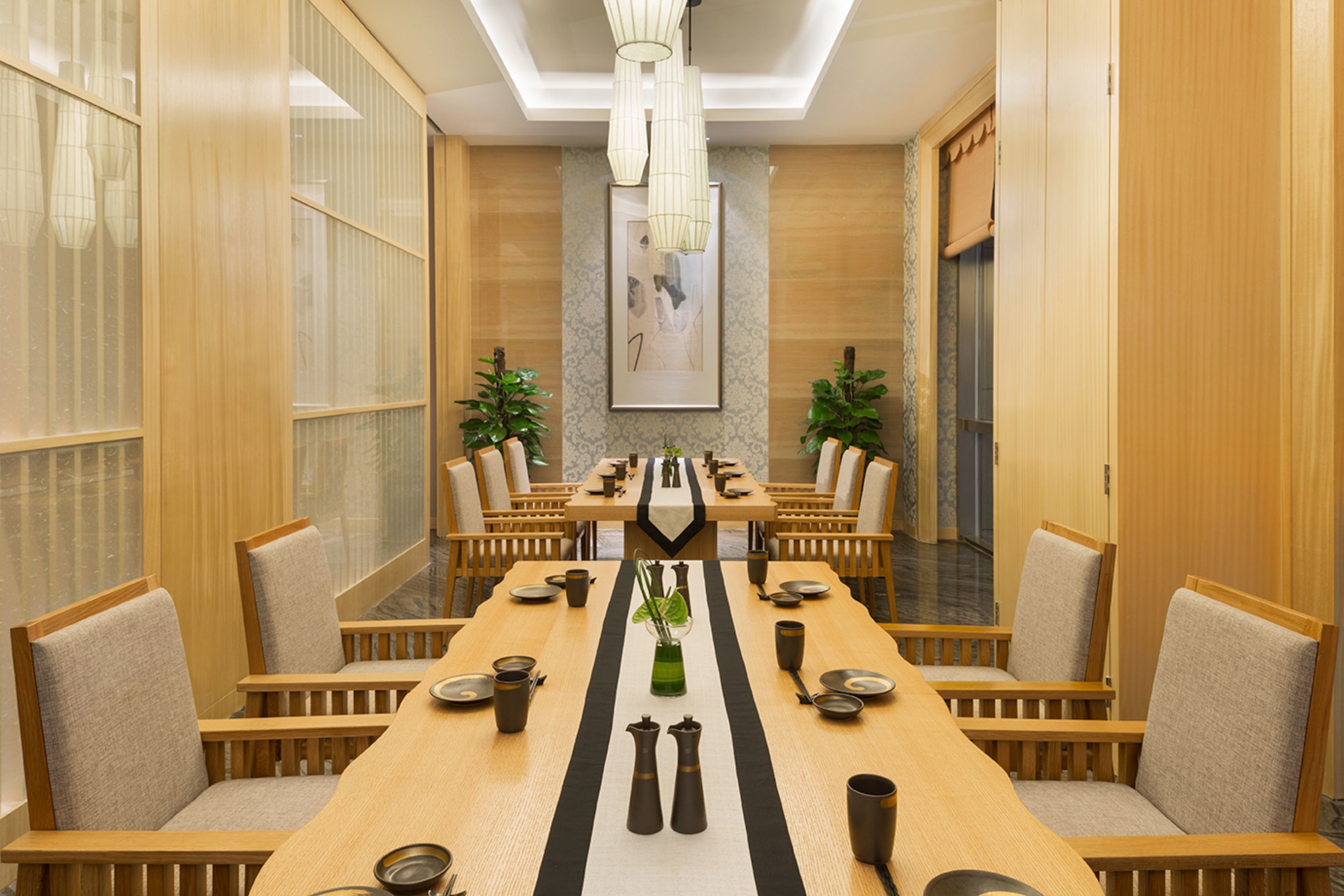Un salón de conferencias con una larga mesa, sillas y un centro de mesa decorativo.