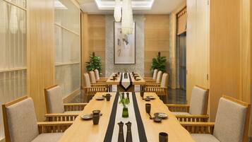 Un salón de conferencias con una larga mesa, sillas y un centro de mesa decorativo.
