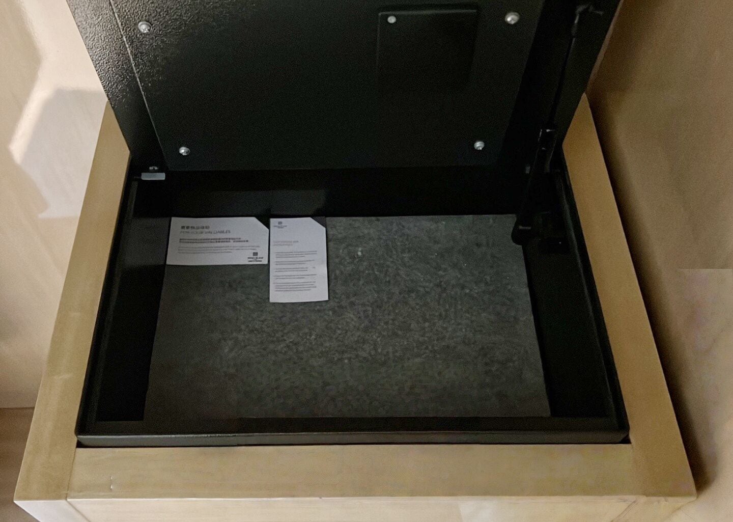 A closed drawer with a black interior and a label on the front.